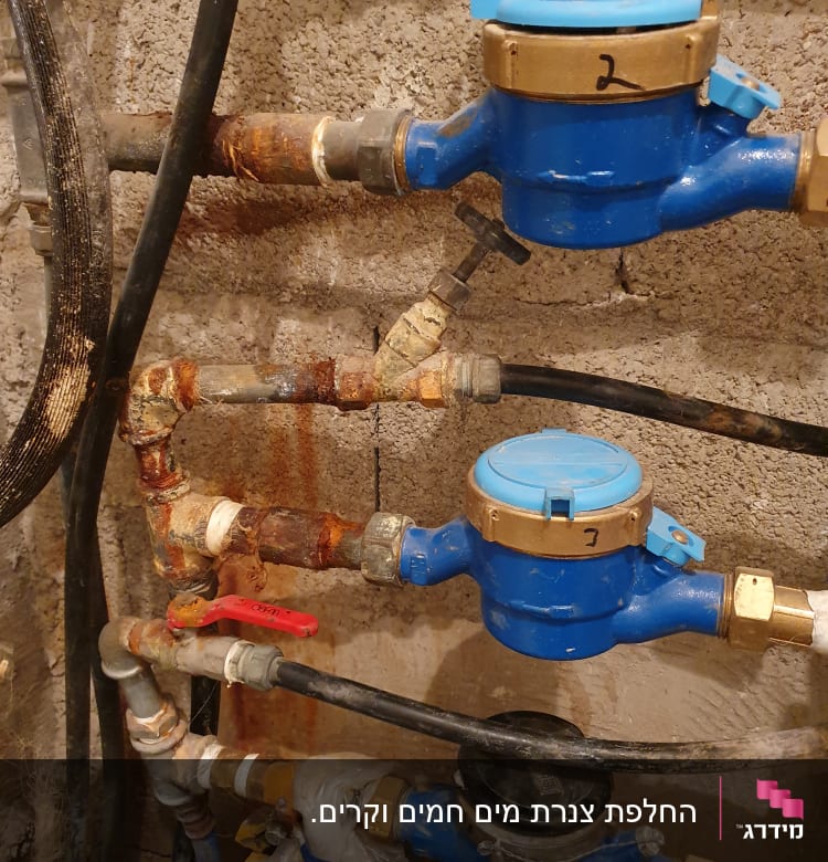מד מים כחול עם צינורות וברזים חלודים